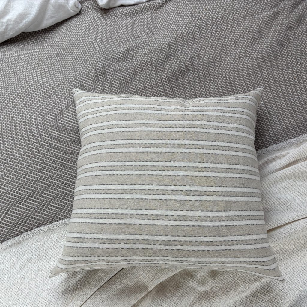 Nahansicht der gestreiften Málaga-Kissenhülle auf einem Sofa